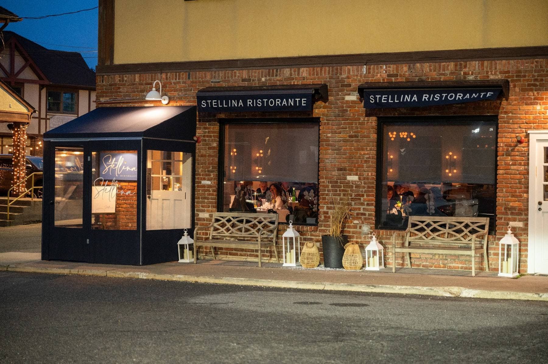 The exterior of Stellina Ristorante at night, with warm lanterns